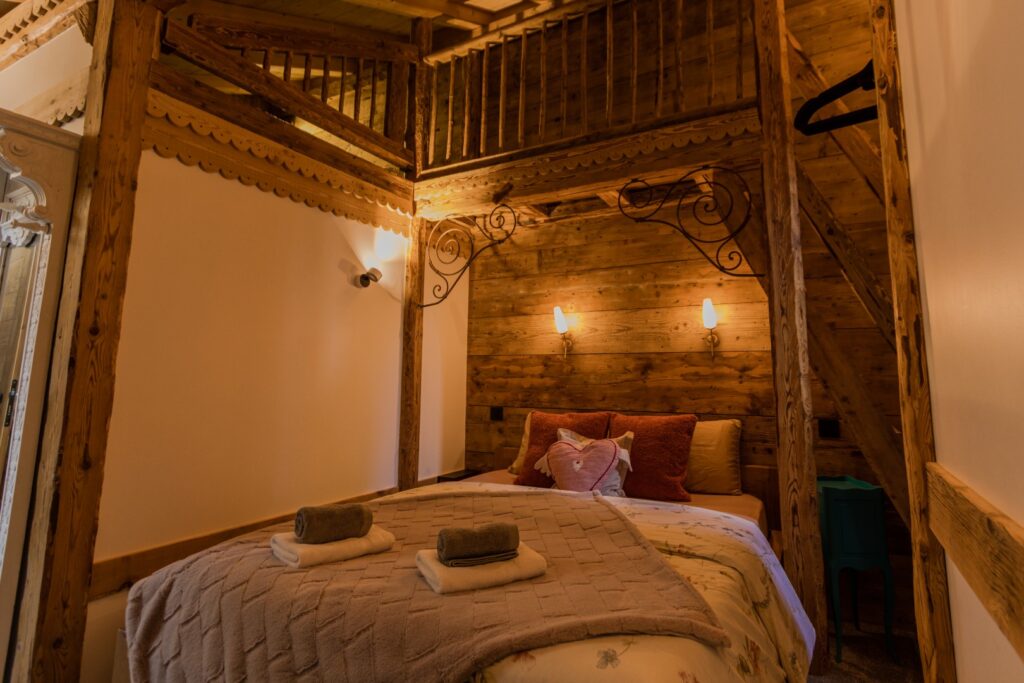Chambre double en suite avec mezzanine, déco bois et fer forgé, lit magnifiquement drapé