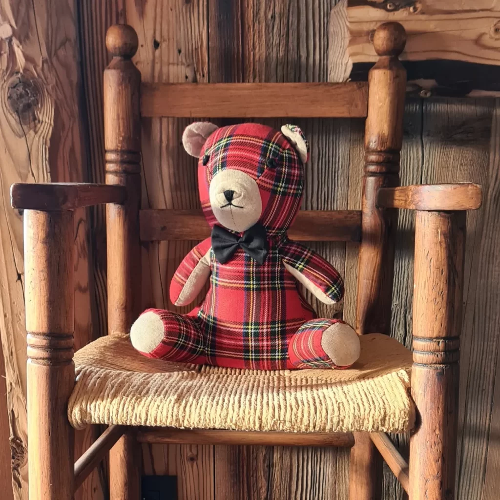 Ours en peluche tartan sur chaise enfant vintage, mur en bois en arrière-plan